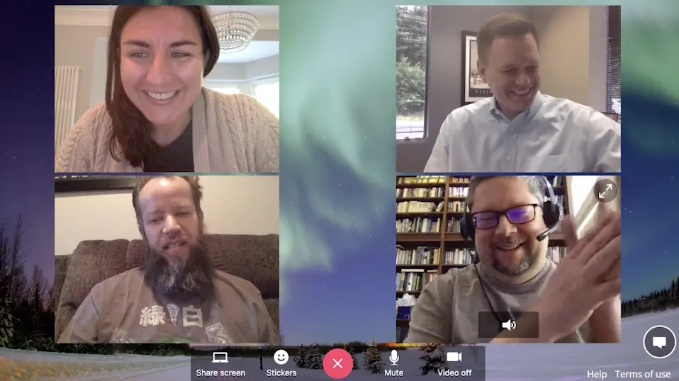 Four people each dialling into a group video call separately from their own homes