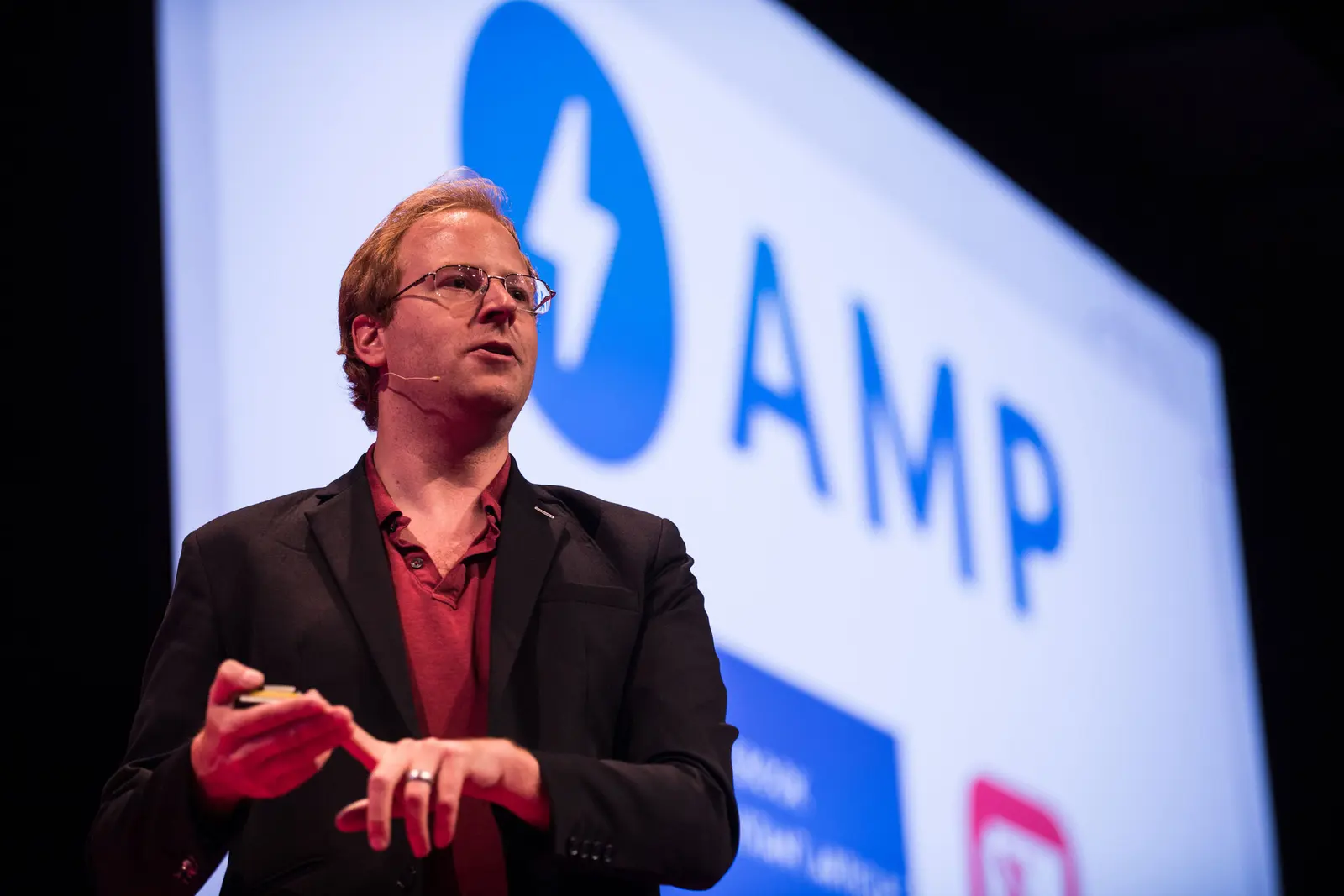 Jono Alderson speaking at Turing Fest with the AMP logo projected behind him