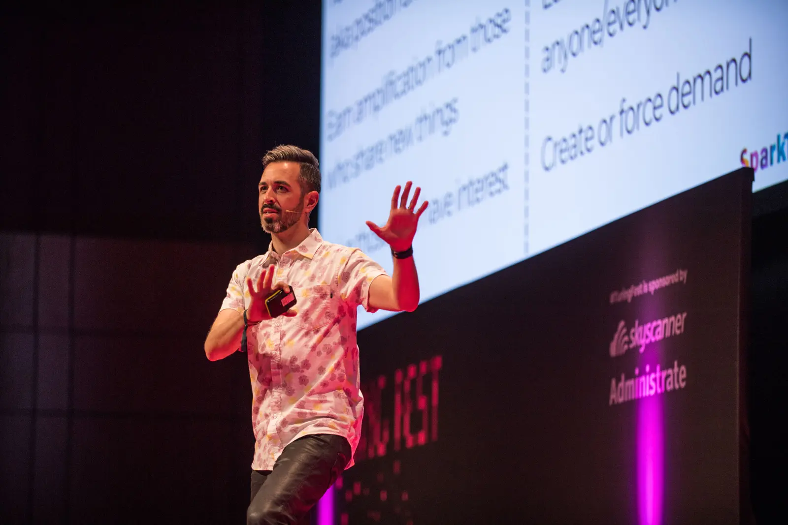 Rand Fishkin gesturing on stage during his Turing Fest 2018 keynote, a slide behind him