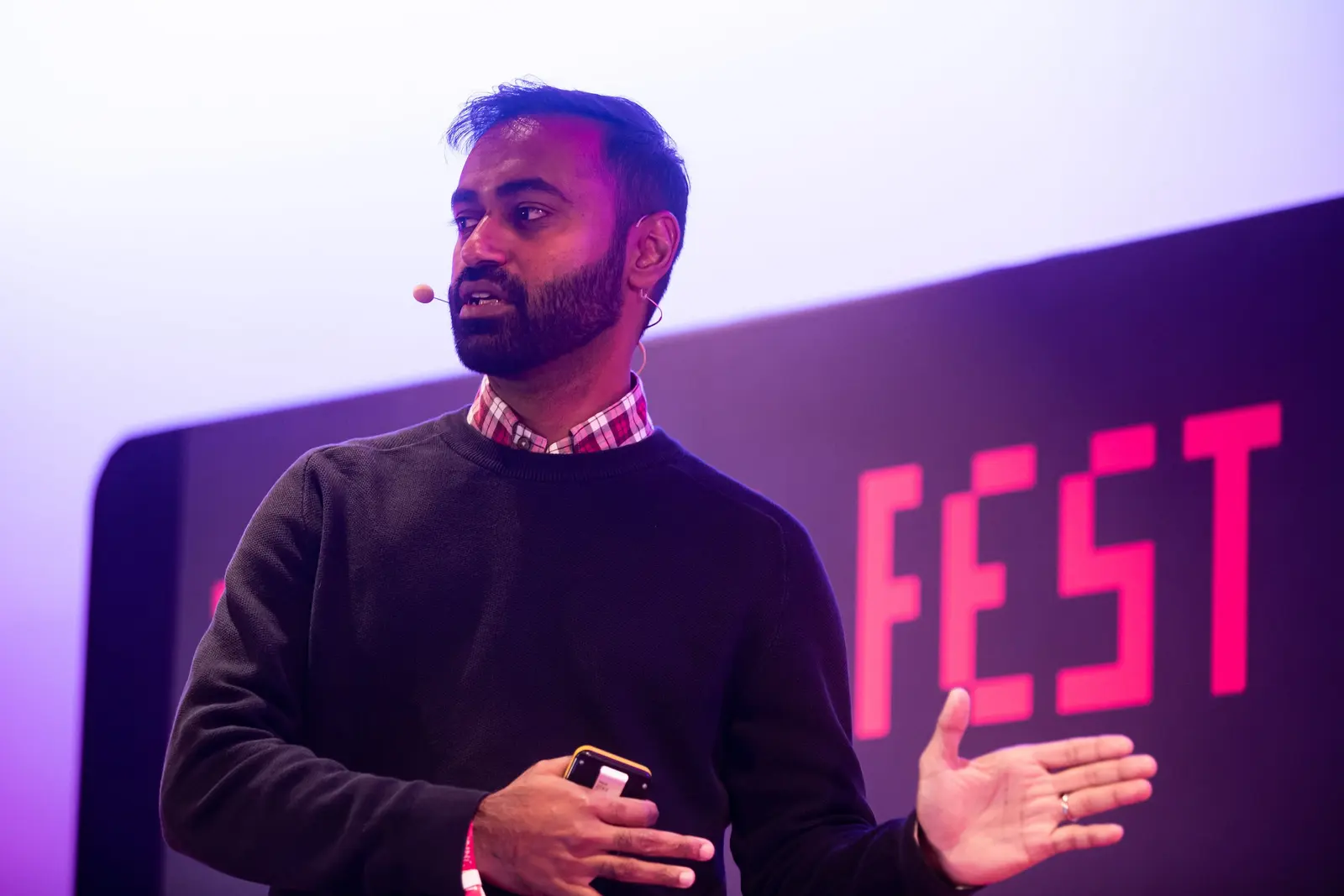 Speaker gesturing on stage at Turing Fest 2021