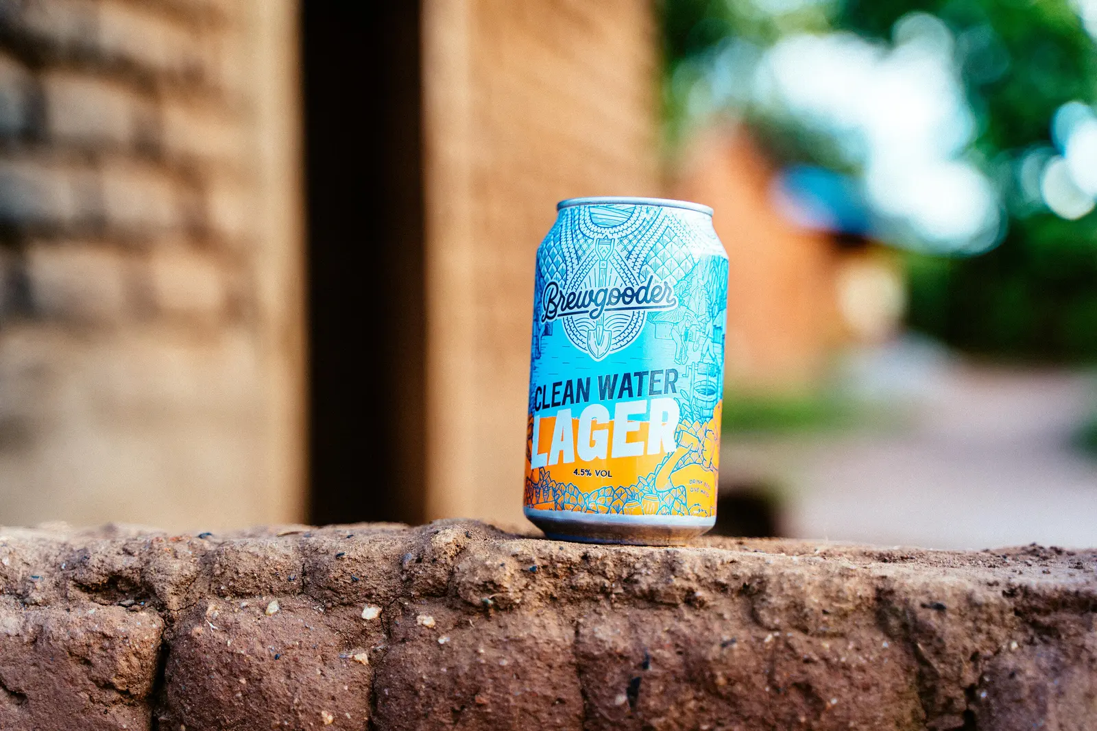 Can of Brewgooder Clean Water Lager, 4.5% vol, resting on a sunlit brick wall